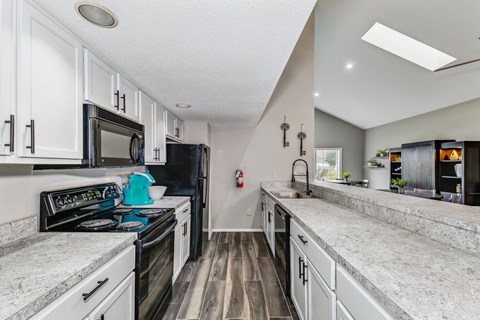 a kitchen with marble counter tops and white cabinets