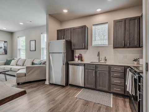 a kitchen and living room with a refrigerator and a sink