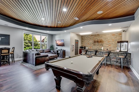 a game room with a pool table and a bar