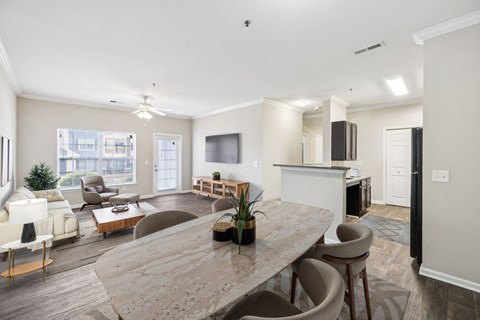 A spacious living room with a large marble table and comfortable seating.