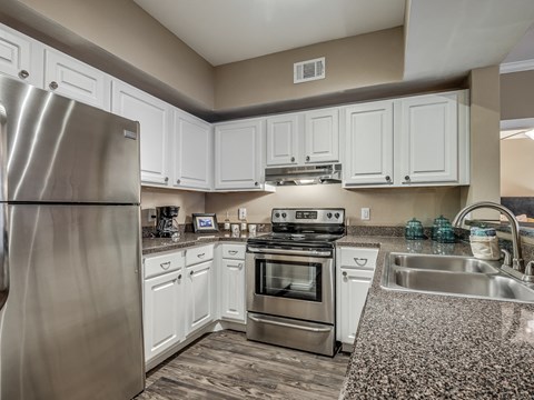 a kitchen with stainless steel appliances and white cabinets