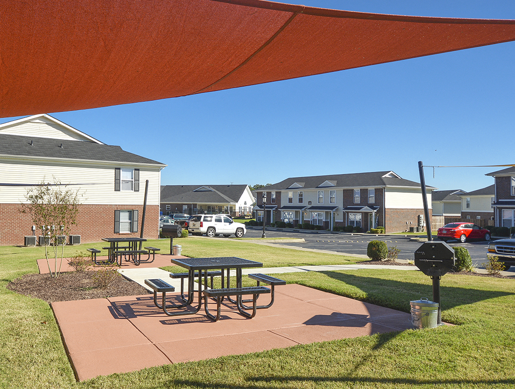 Outdoor Grilling Area with Sun Canopy and Picnic Tables