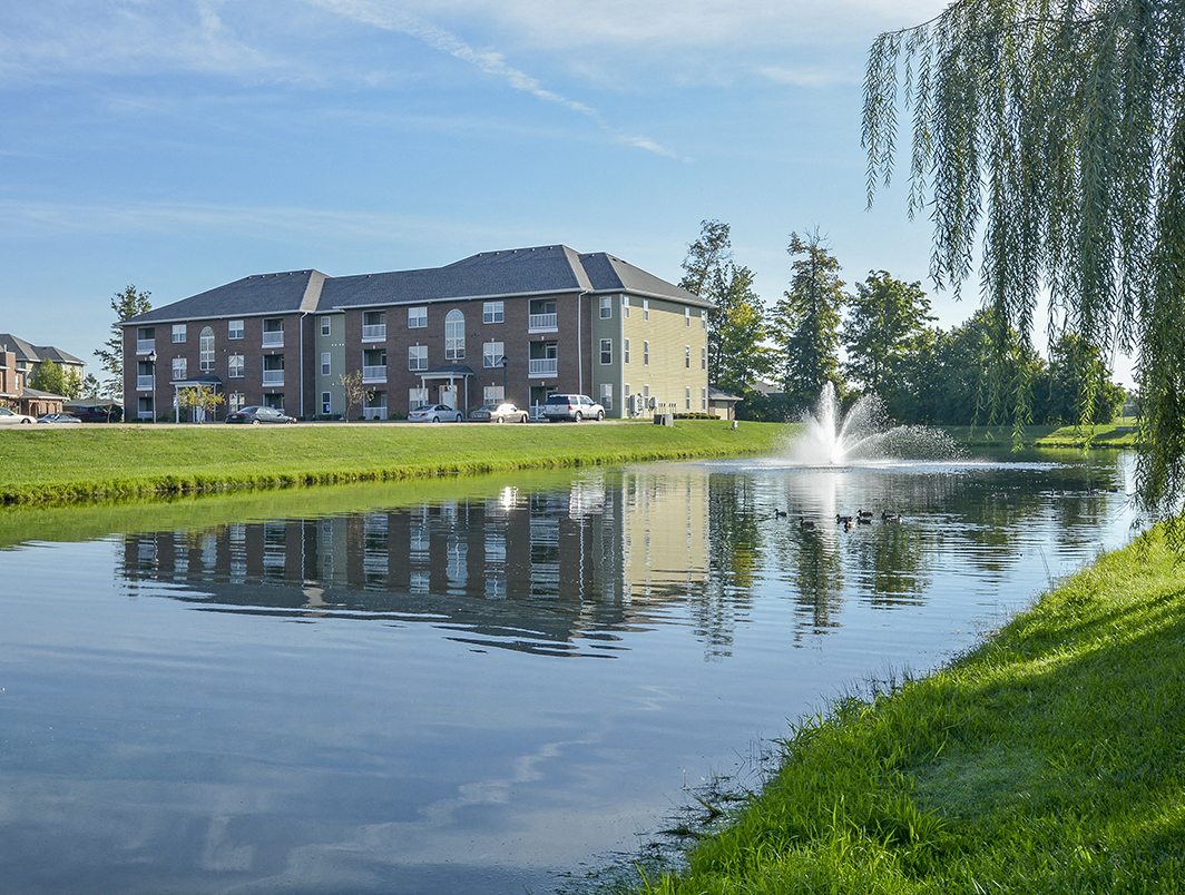 Lush Green Grass Surrounding the Large Pond with Fountain