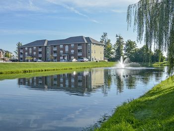 Lush Green Grass Surrounding the Large Pond with Fountain