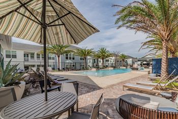 Table & Chairs With Umbrella At The Pool Sundeck