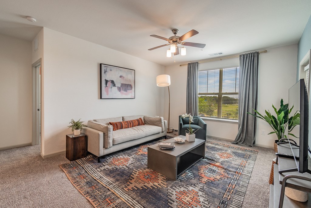 Carpeted Living Room With Tall Ceilings & Large Windows