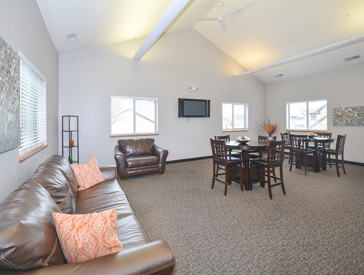 a living room with a leather couch and a dining room table