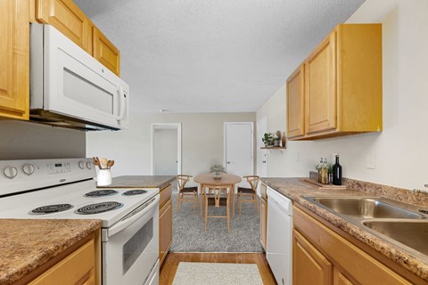 a kitchen with white appliances and wooden cabinets