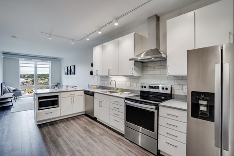 an open kitchen with stainless steel appliances and white cabinets