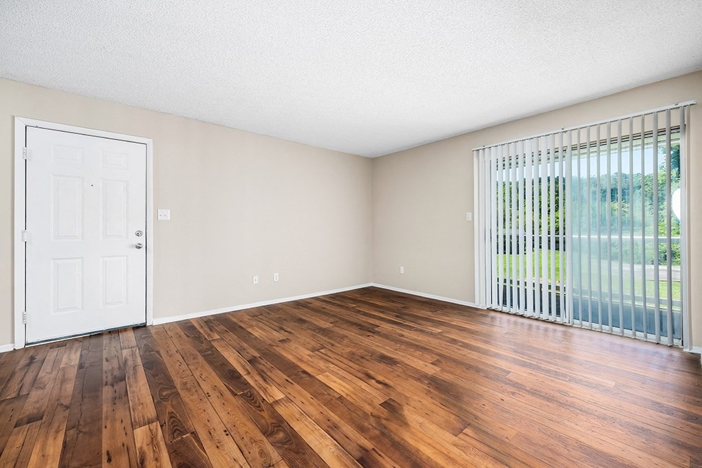 Living Room Area With Wood-Style Flooring & Glass Sliding Patio Door With Built-In Blinds