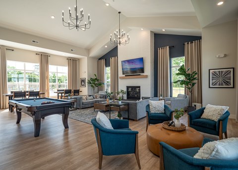 A living room with a pool table and a television.