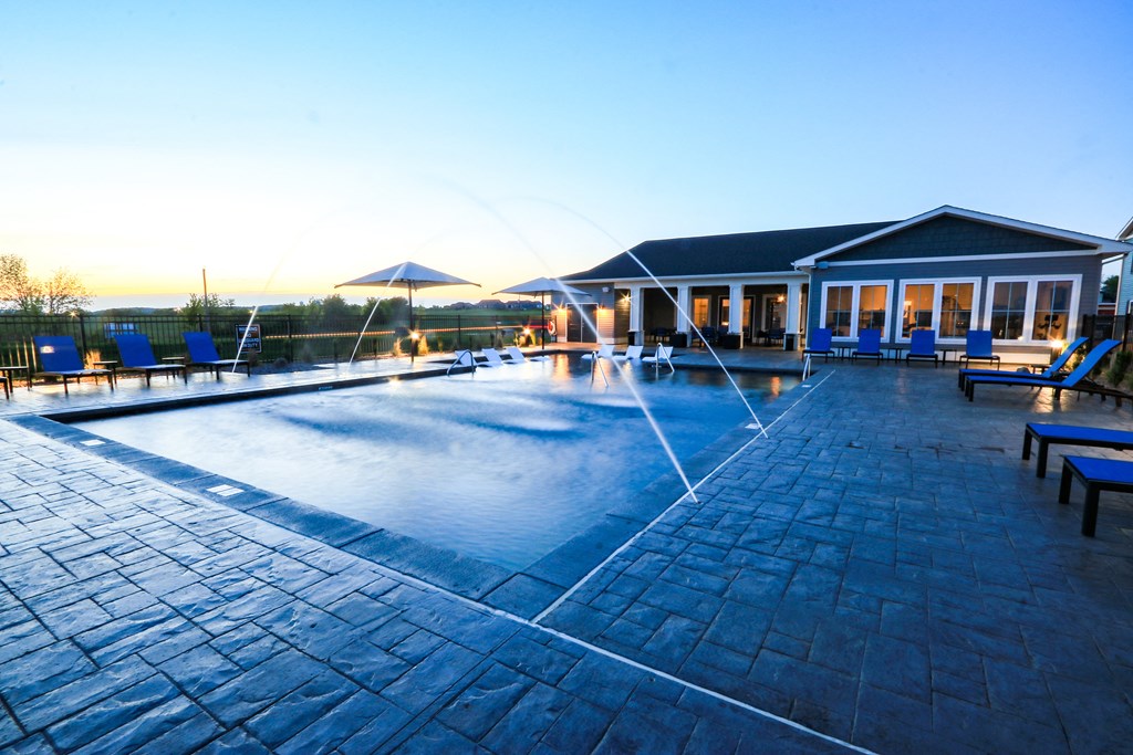 Resort-Style Pool With Fountains At Dusk