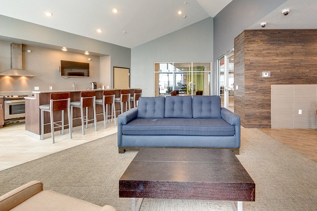 a living room with a blue couch in front of a bar