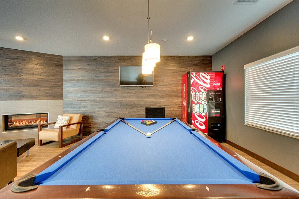 a game room with a pool table and a coke machine