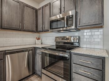 Kitchen with Dark Brown Cabinetry and Stainless Steel Appliances