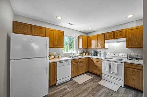 A kitchen with wooden cabinets and white appliances.
