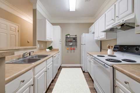 A kitchen with white cabinets and a beige countertop.