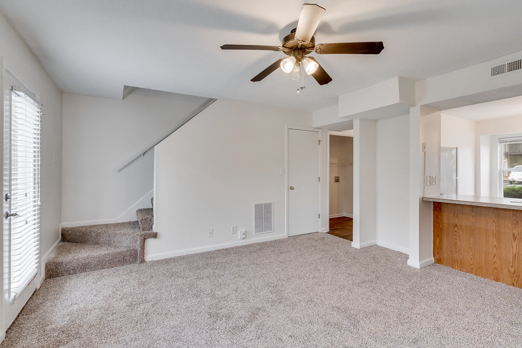 Carpeted Living Room With Stairwell Leading Upstairs