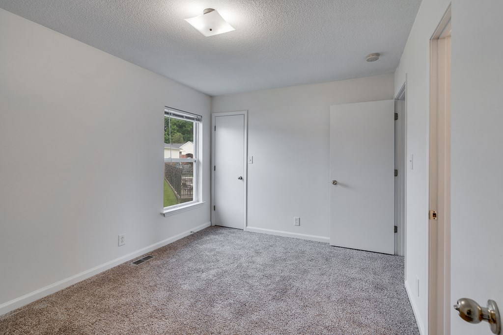 Carpeted Bedroom With Large Window
