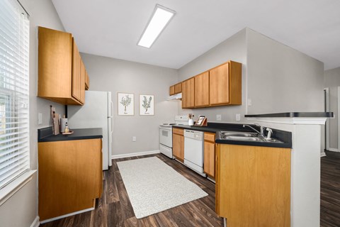 a kitchen with wooden cabinets and white appliances and a window