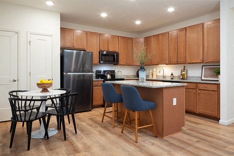 a kitchen with wooden cabinets and a table with chairs