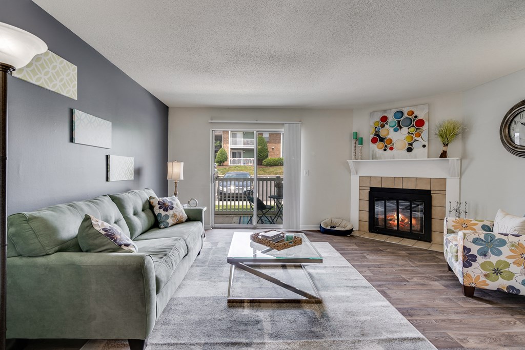 Spacious Living Room With Wood-Style Flooring, Fireplace, & Glass Patio Door