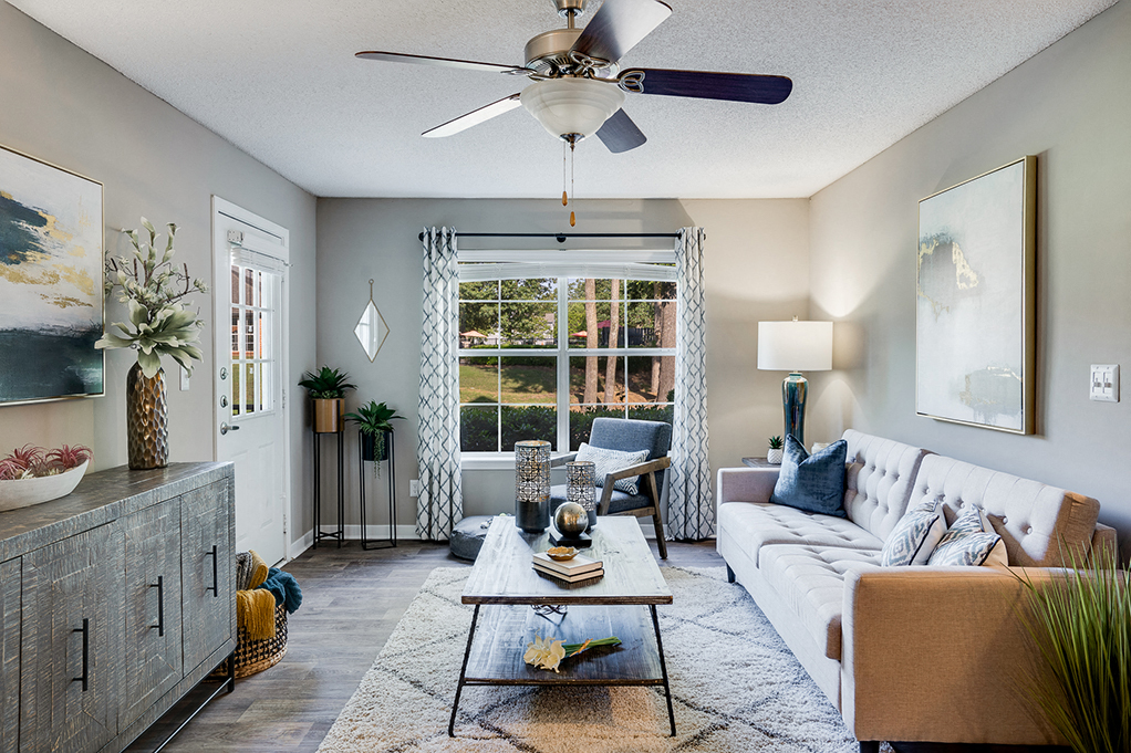 a living room with a white couch and a ceiling fan