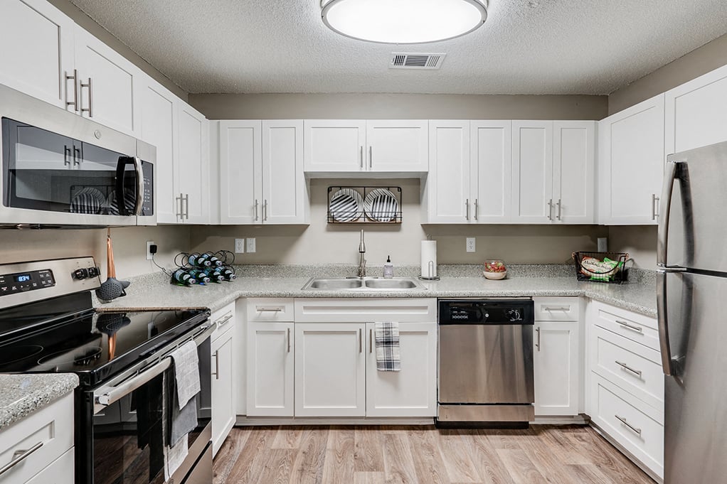 an expansive kitchen with white cabinets and stainless steel appliances