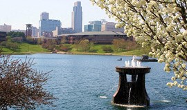 a fountain in a lake with a city in the background