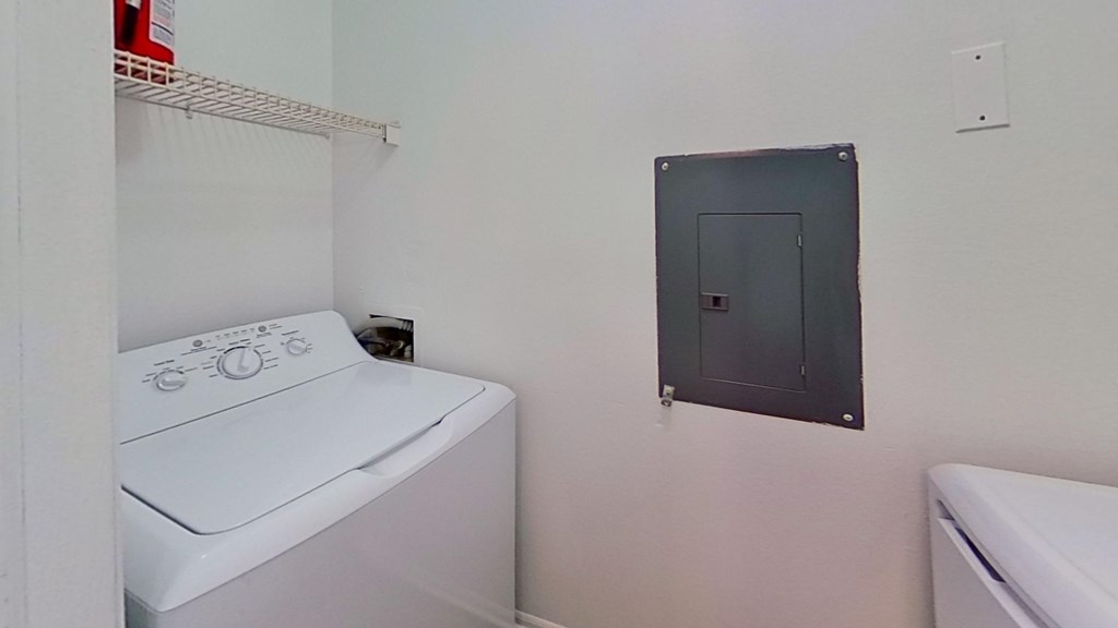 A white washing machine sits in a laundry room.
