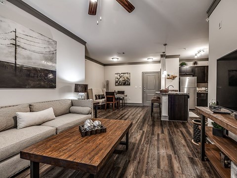 A modern living room with a wooden floor and a grey sofa.