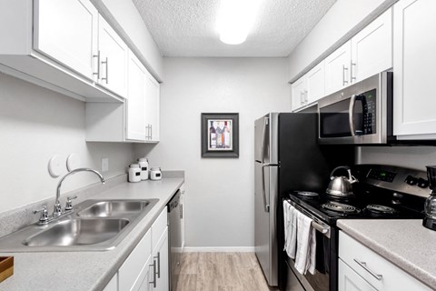 a modern kitchen with stainless steel appliances and white cabinets