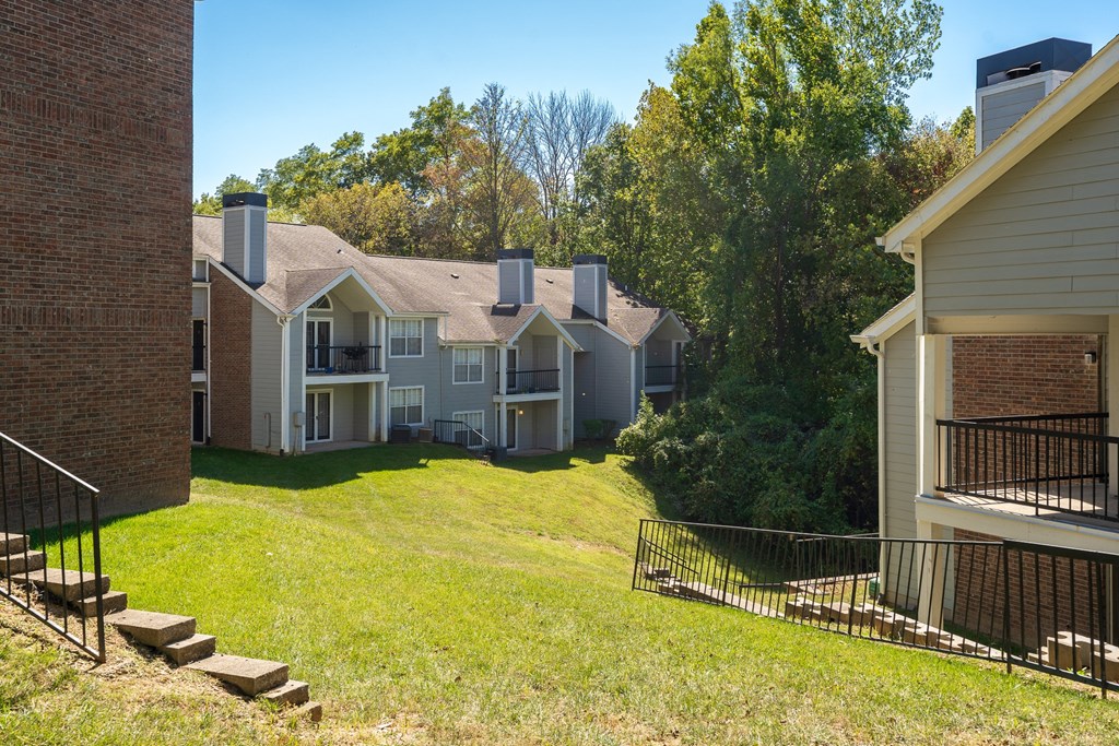 Large Grass Area with Sloping Hill Between Pelican Cove Apartment Buildings