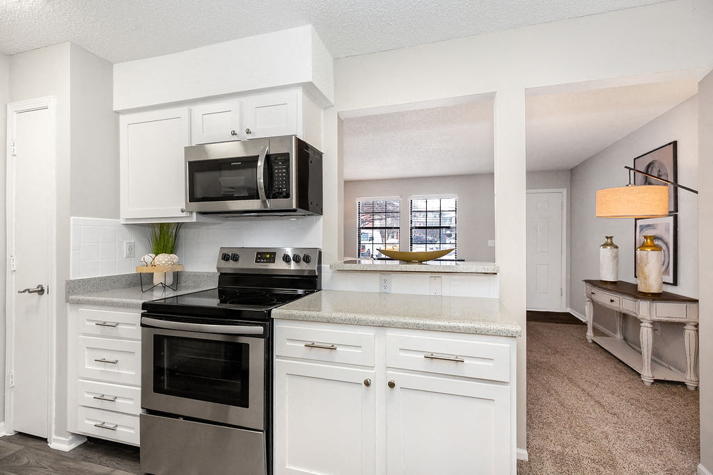 Renovated Kitchen with White Tile Backsplash and Stainless Steel Appliances