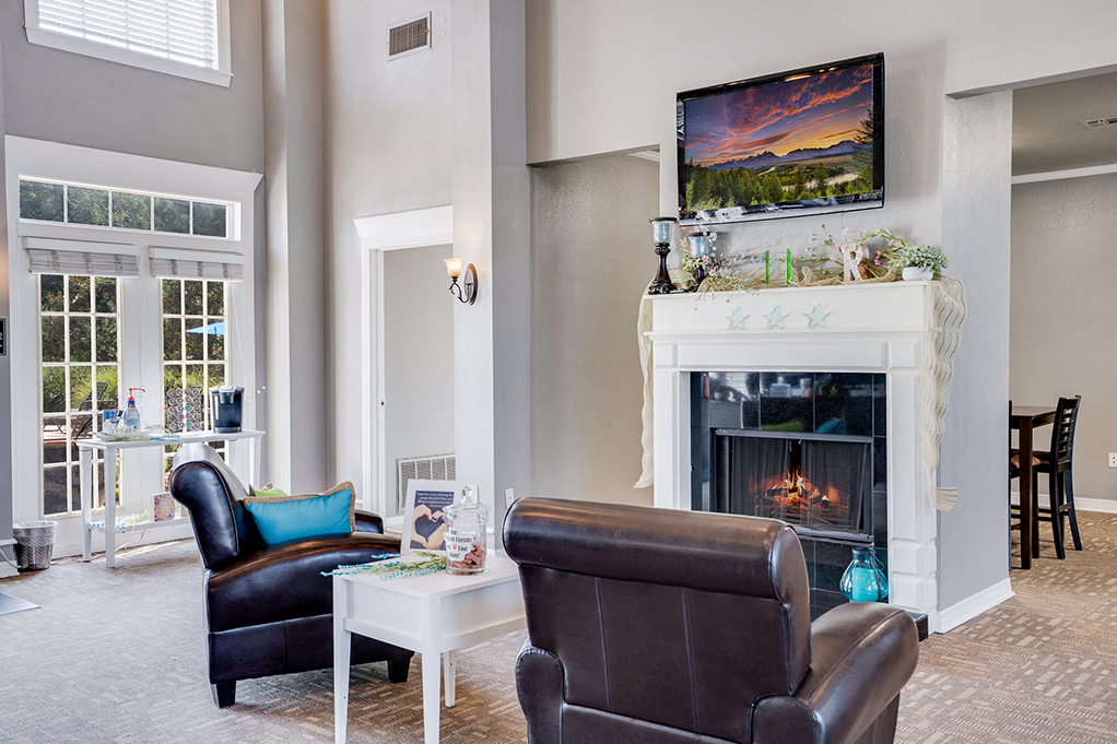 a living room with a fireplace and leather furniture