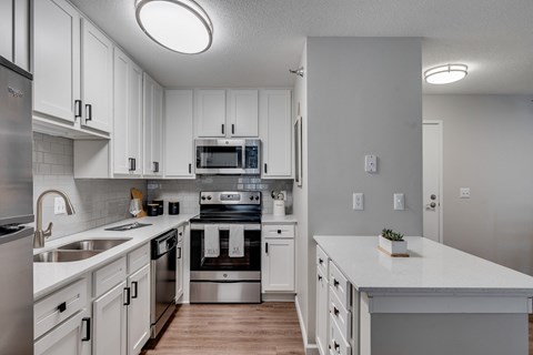an expansive kitchen with white cabinets and stainless steel appliances