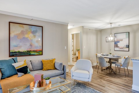 A living room with a grey couch, a coffee table, and a painting on the wall.