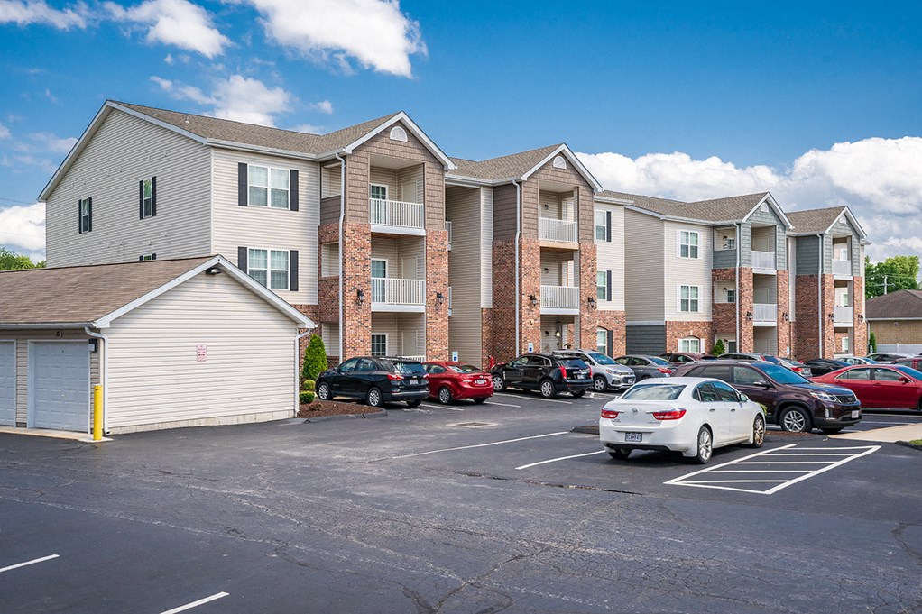a parking lot with cars in front of an apartment building