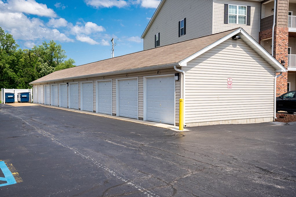 a garage with white doors and a parking lot