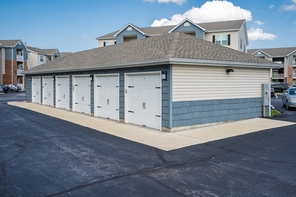 a small garage with four doors on the side of a street