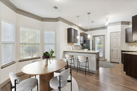 A modern kitchen with a dining table and chairs.