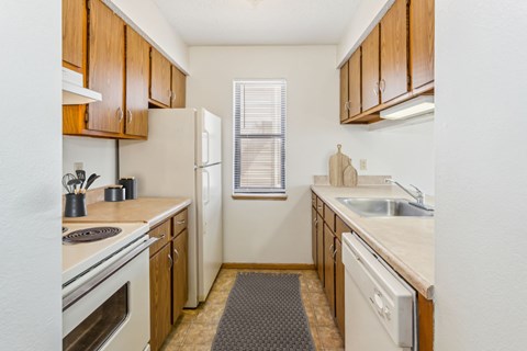 A kitchen with wooden cabinets and a white refrigerator.