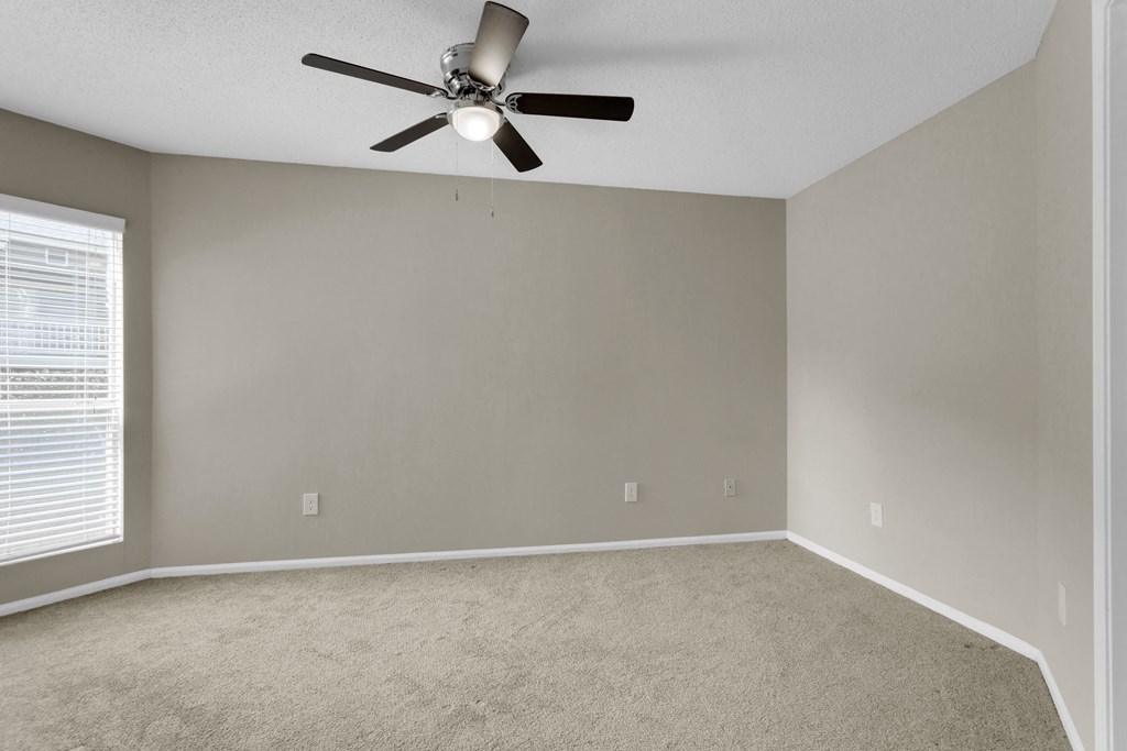 Spacious Carpeted Bedroom With Ceiling Fan