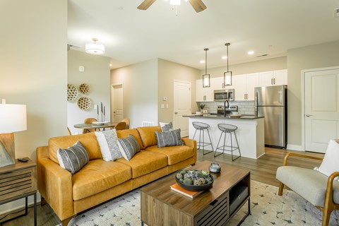 A modern living room with a yellow couch and a wooden coffee table.