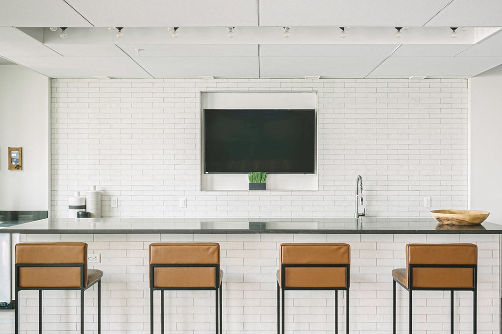 Bar with stools, mounted television and tiled backsplash