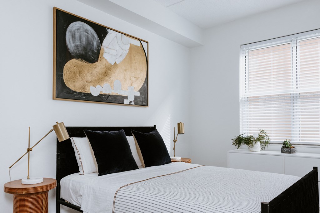 a bedroom with a large bed and a large painting on the wall