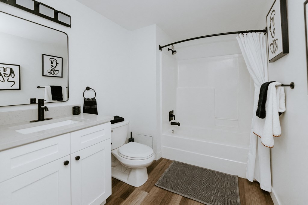 a bathroom with a white toilet next to a bathtub with a shower curtain