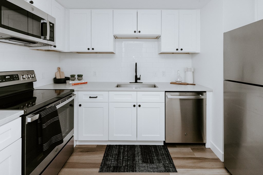 a kitchen with white cabinets and stainless steel appliances