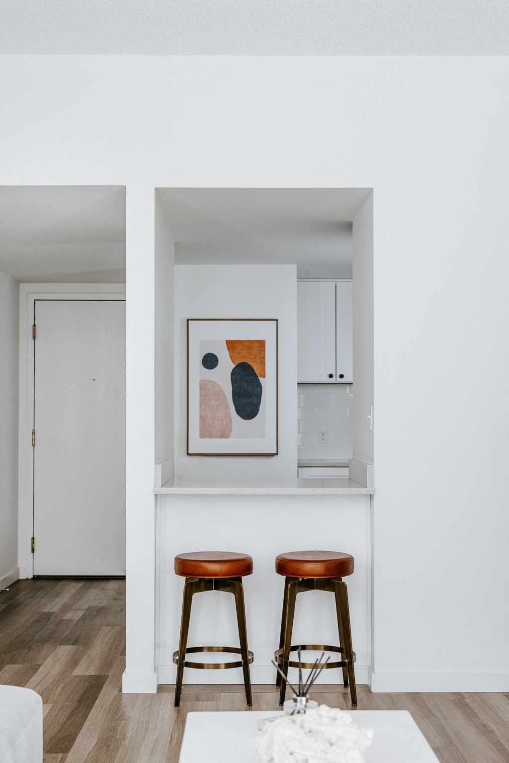a small kitchenette with two stools in a 555 waverly unit