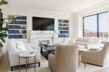Lounge with built-in bookshelves, mounted television, soft seating and view of city out windows - Photo Gallery 30